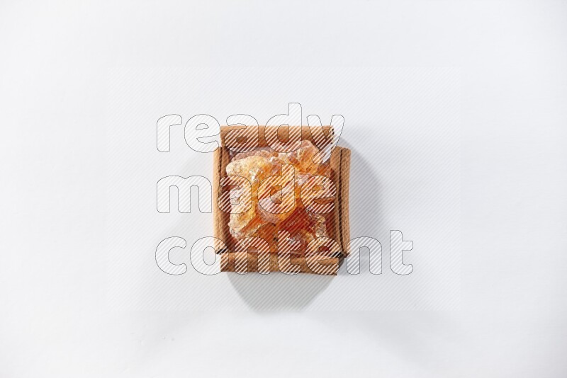 A single square of cinnamon sticks full of Arabic gum on white flooring