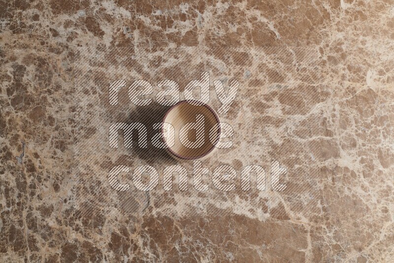 A beige pottery bowl on beige marble background