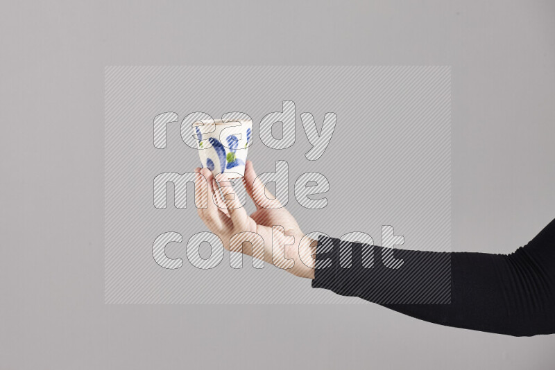 A woman in black abaya holding different pottery essentials in different positions