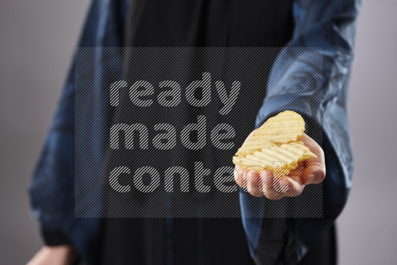 امرأة ترتدي عباءة تحمل أنواع مختلفة من الوجبات الخفيفة في أوضاع متعددة