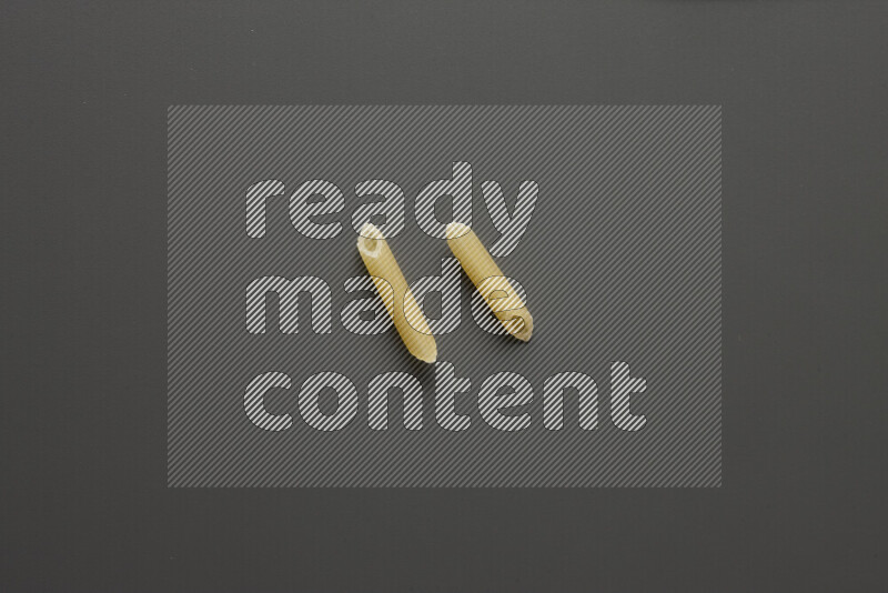 Mini penne pasta on grey background
