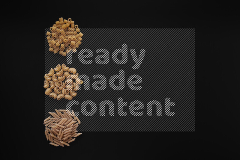 Different pasta types in 3 bunches on black background