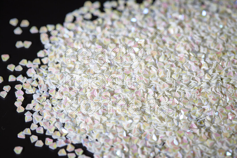 قطع صغيرة بلاستيكية ملونة للزينة متناثرة على خلفية سوداء