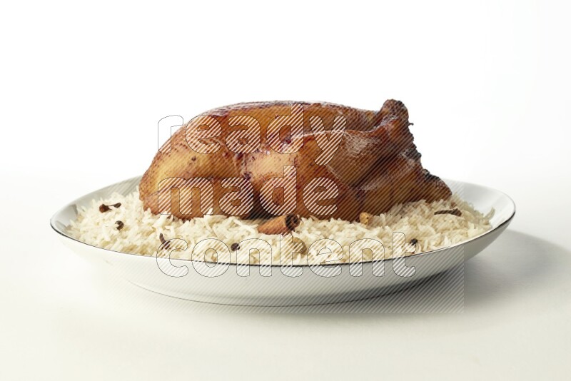 white  basmati Rice with  whole roasted chicken  on a white plate with a silver rim direct  on white background