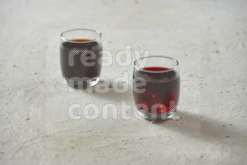 Cold drinks in a glass cup such as water, tamarind, qamar eldin, sobia, milk and hibiscus on textured white background