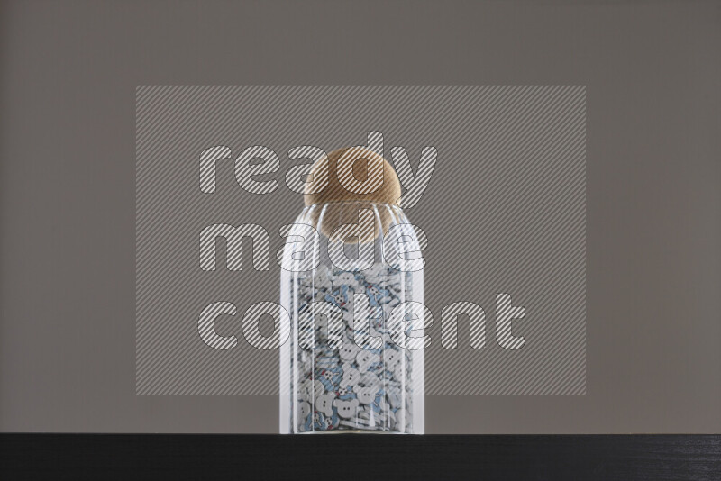 Buttons in a glass jar on black background