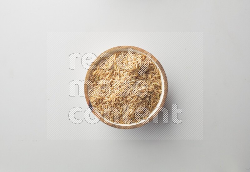 Top-view shot of long grain brown rice in a container on white background