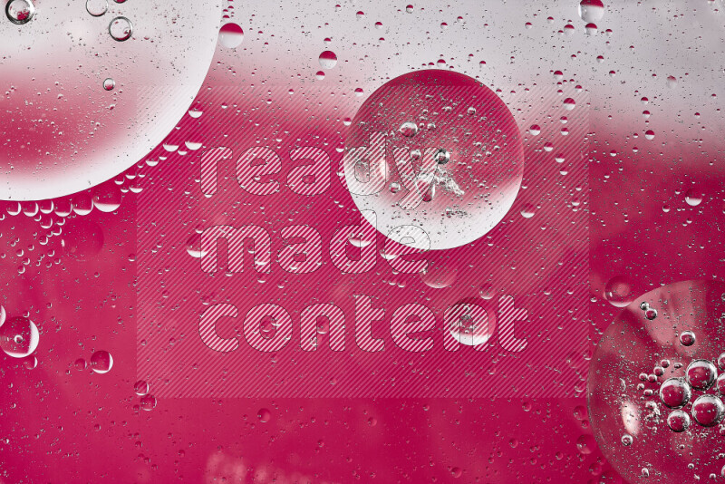 Close-ups of abstract oil bubbles on water surface in shades of white and pink