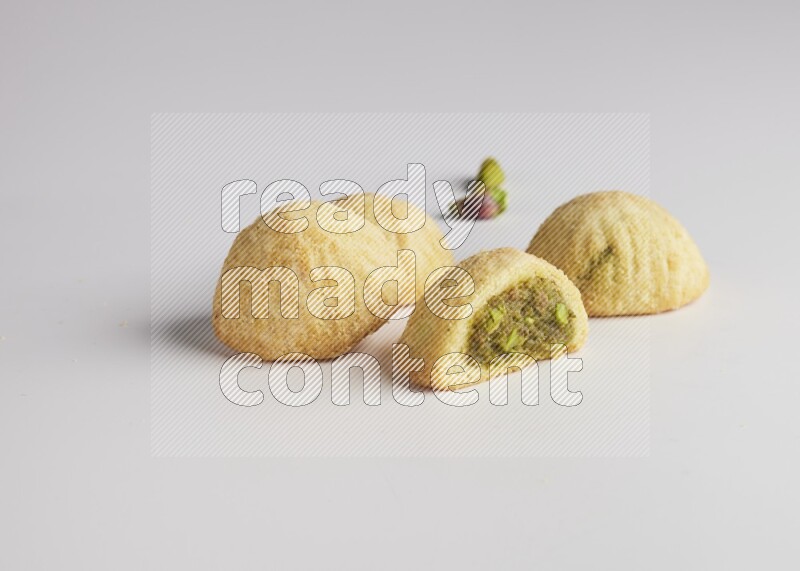 Four Pieces of Maamoul filled with pistachio  paste one of them is cut direct on white background