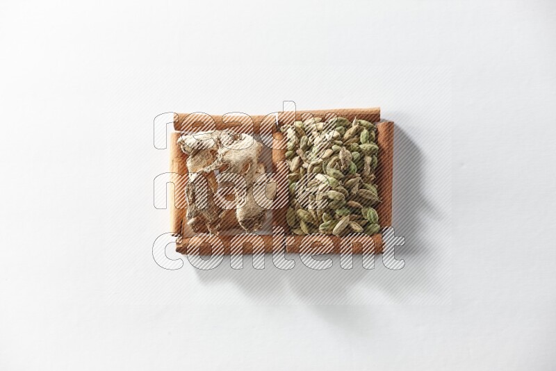 2 squares of cinnamon sticks full of cardamom and dried ginger on white flooring