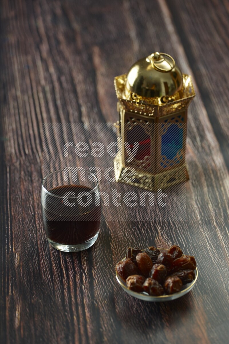 A golden lantern with different drinks, dates, nuts, prayer beads and quran on brown wooden background