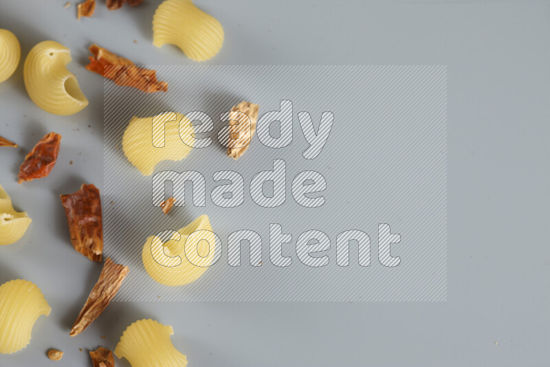 معكرونة مع مكونات متنوعة من الطماطم والثوم والبصل والفلفل الأحمر والفلفل الأسود والفلفل الأبيض وأوراق الغار وإكليل الجبل والهيل و مشروم على خلفية زرقاء فاتحة