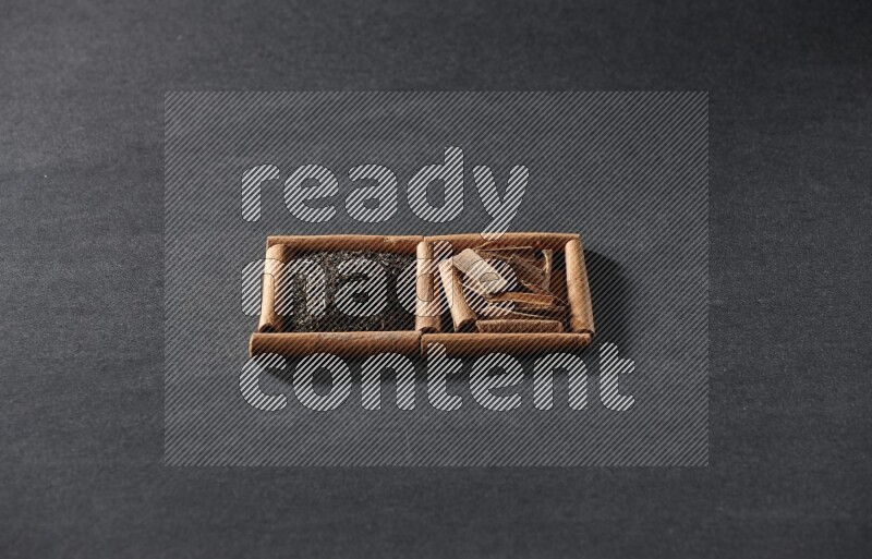 2 squares of cinnamon sticks full of tea and cinnamon on black flooring