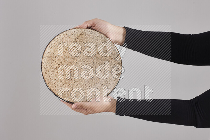 A woman in black abaya holding different pottery essentials in different positions