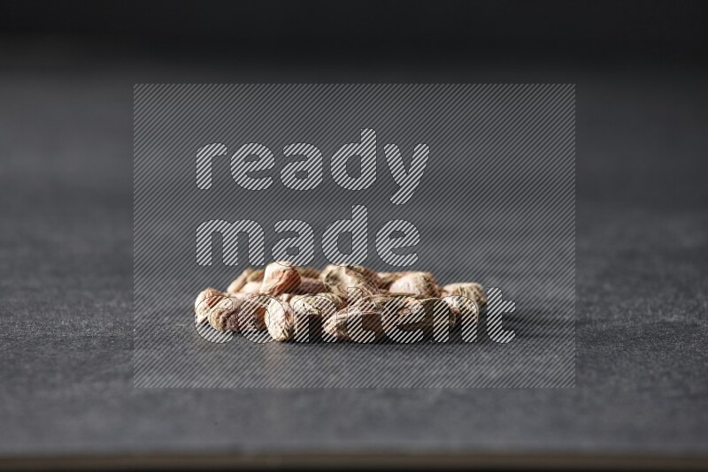 A bunch of peeled pistachios on a black background in different angles