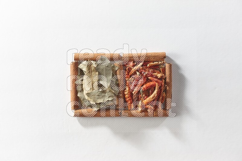 2 squares of cinnamon sticks full of dried red chilis and bay laurel leaves on white flooring