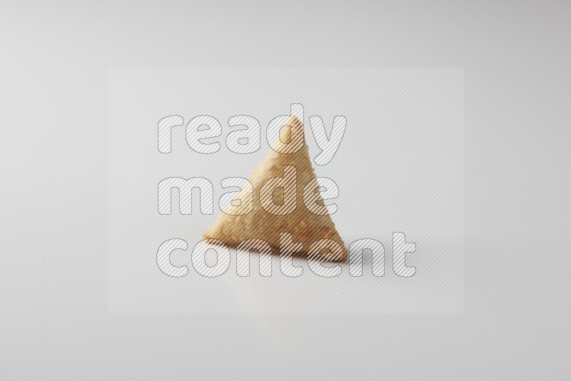 One fried sambosa on a white background