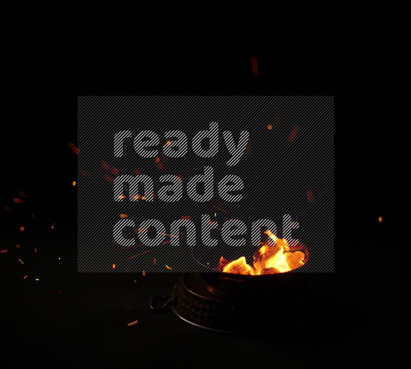 Coal cubes on fire in metal pan