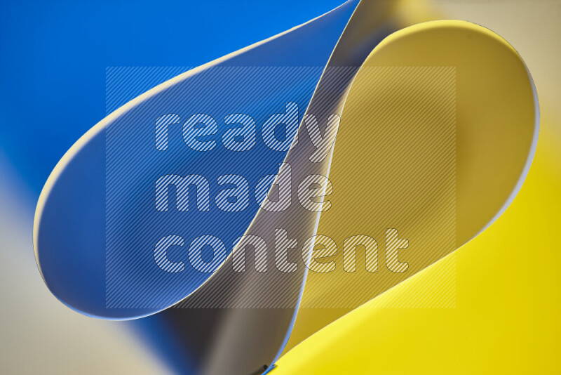 An abstract art of paper folded into smooth curves in blue and yellow gradients