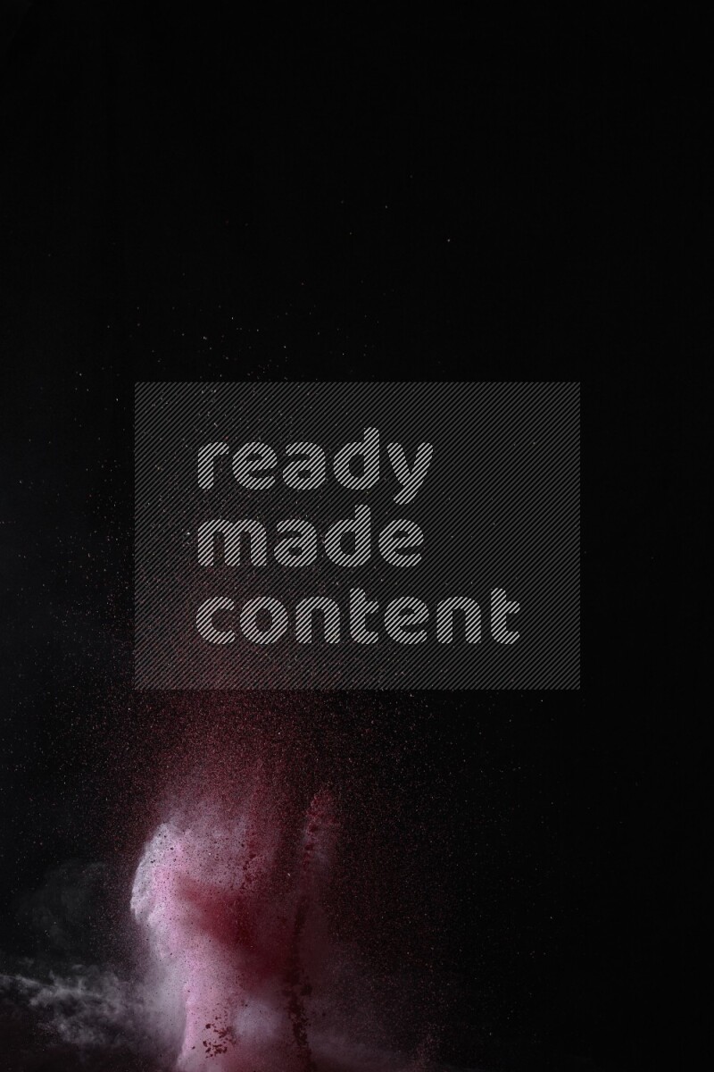 A side view of red powder explosion on black background