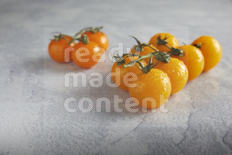 Mixed cherry tomato veins on a textured light grey background 45 degree