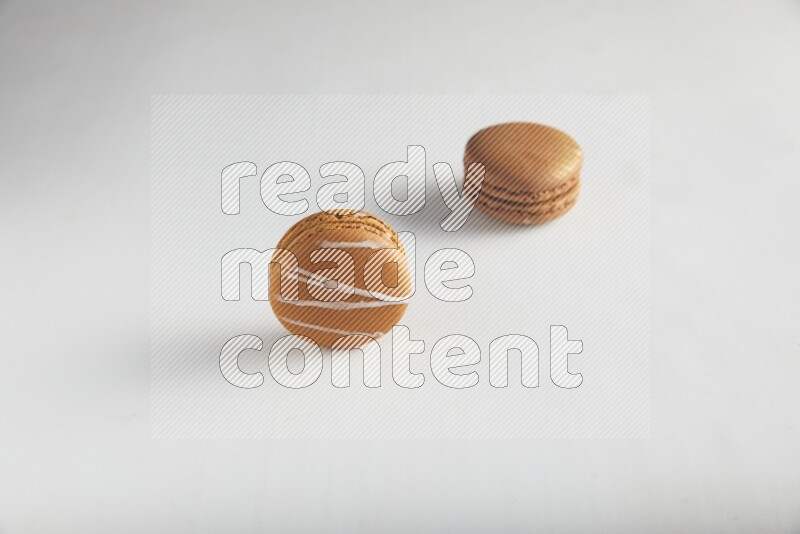 45º Shot of of two assorted Brown Irish Cream, and Brown Coffee macarons  on white background