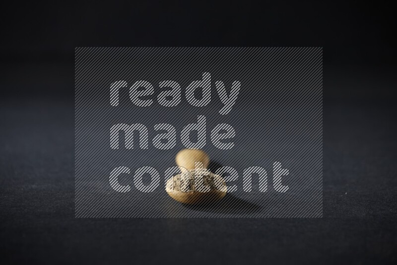 ملعقة خشبية ممتلئة ببودرة الهيل على خلفية سوداء