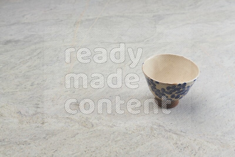 A multicolored pottery bowl on grey marble background