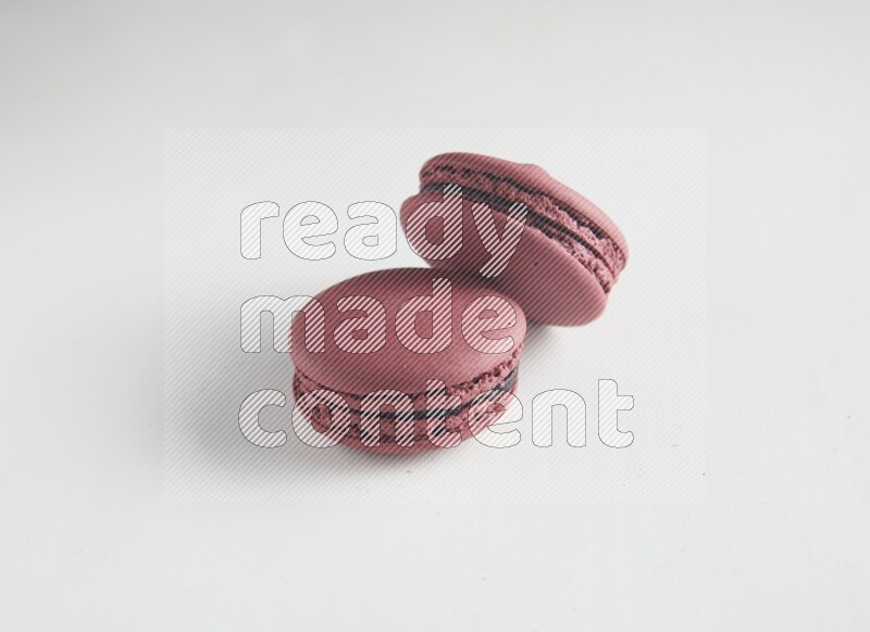 45º Shot of two Red Cherry macarons on white background