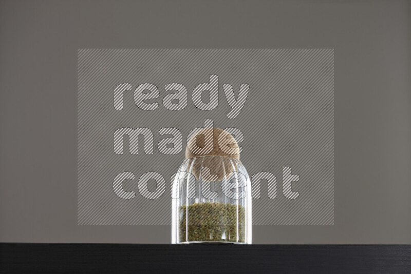 Freekeh in a glass jar on black background