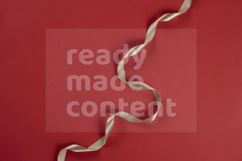 A brown and red collection of sewing and tailoring tools arranged on a red background