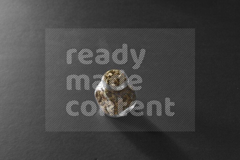 هيل في وعاء زجاجي علي خلفية سوداء