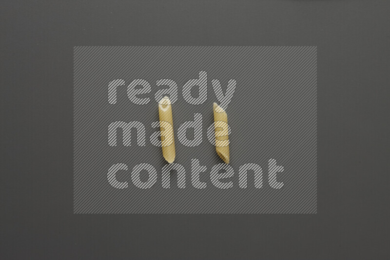 Mini penne pasta on grey background