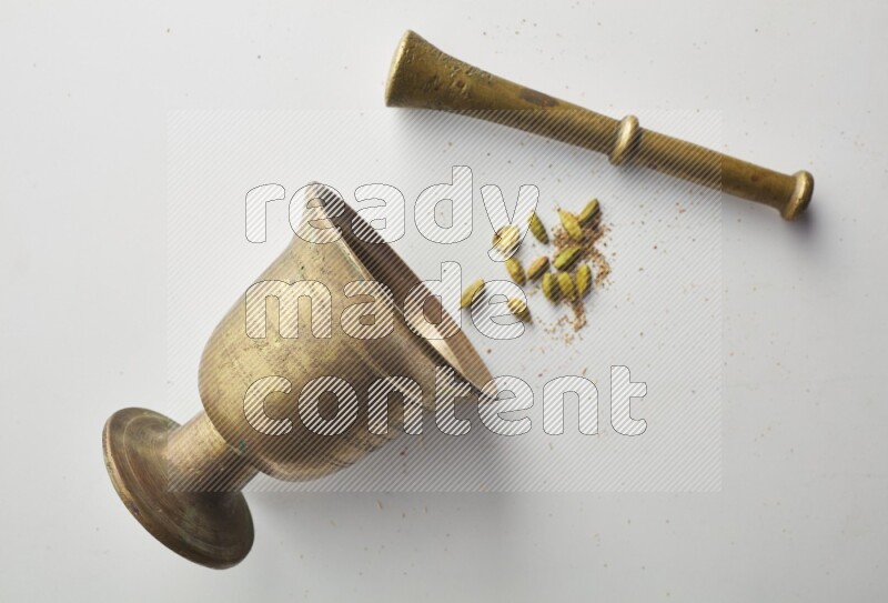 Top-view shot of Cardamon in herbs crusher on white background