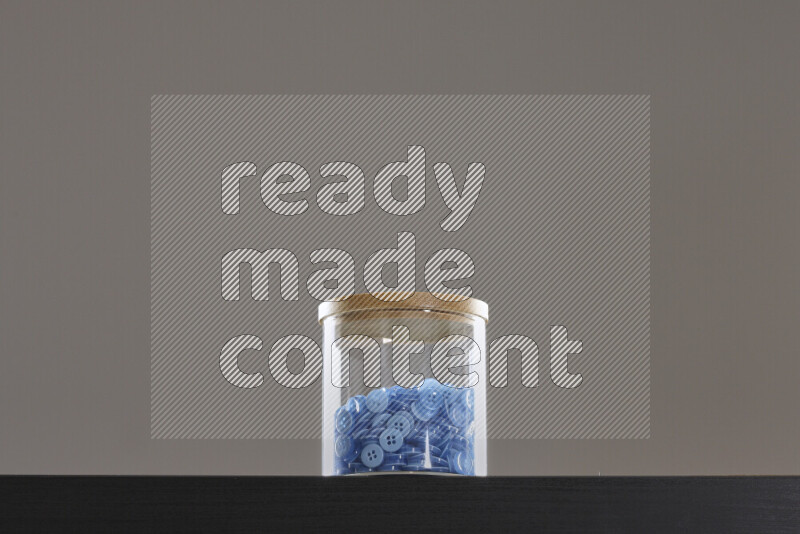 Buttons in a glass jar on black background