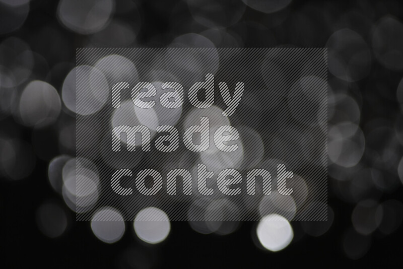 Silver shimmering fragments of glass scattered on a black background