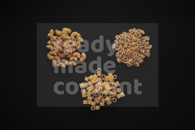 Different pasta types in bunches on black background
