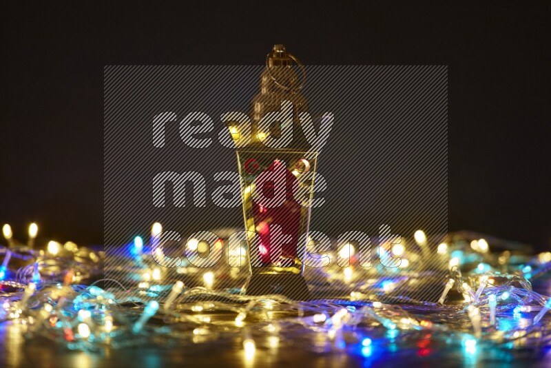 A traditional ramadan lantern surrounded by glowing fairy lights in a dark setup