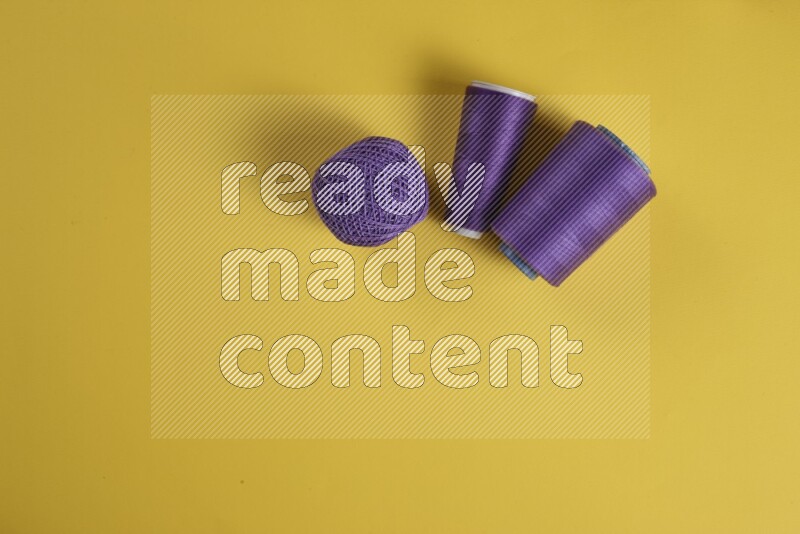 A purple collection of sewing and tailoring tools arranged on a yellow background