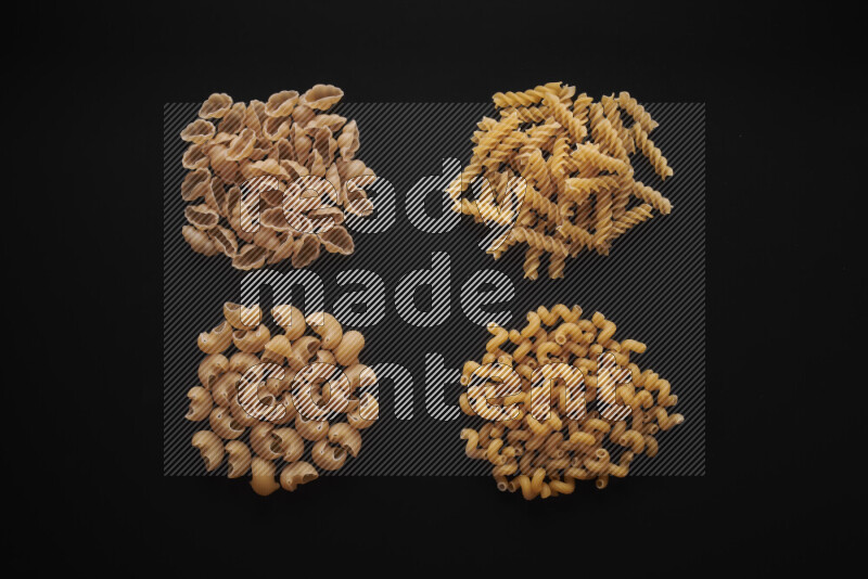 Different pasta types in bunches on black background