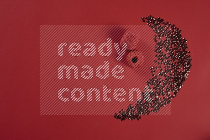 مجموعة من أدوات الخياطة والتفصيل حمراء اللون على خلفية حمراء