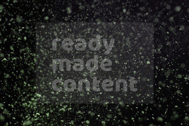 Green powder explosion on black background