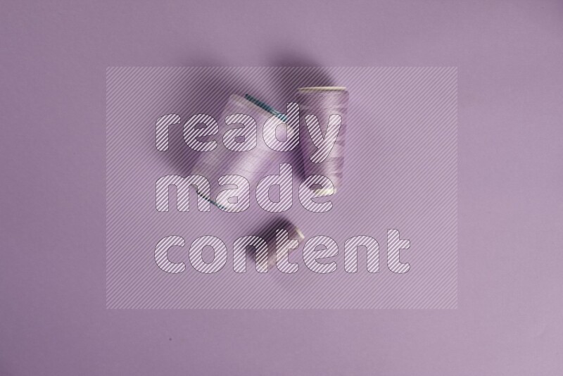 A purple collection of sewing and tailoring tools arranged on a purple background