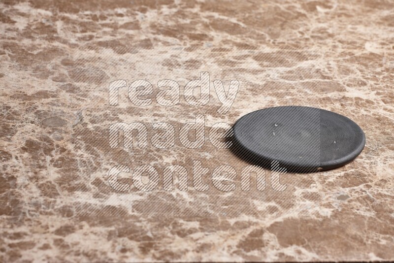 A pottery coaster on beige marble background