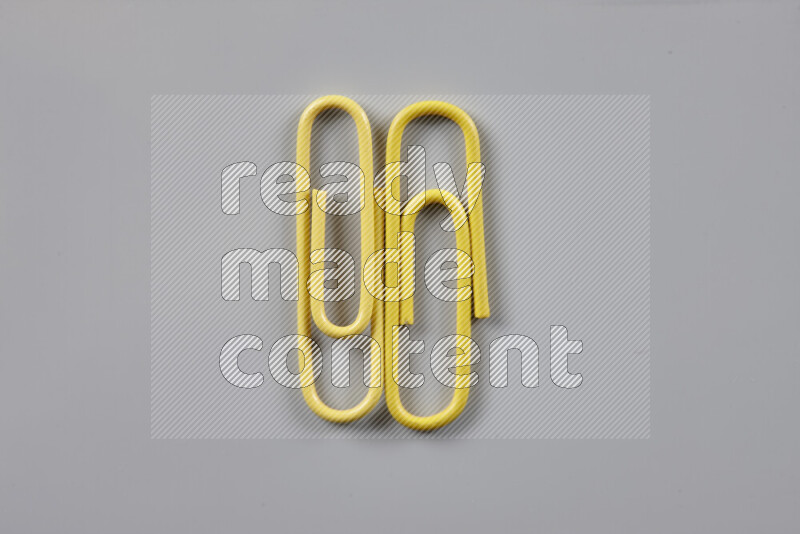 Yellow paper clips isolated on a grey background