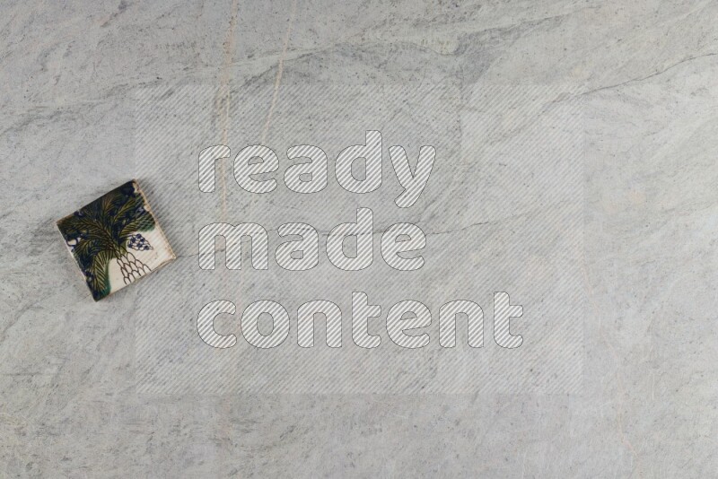 A decorative pottery coaster on grey marble background