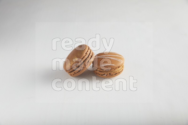 45º Shot of of two assorted Brown Irish Cream, and Brown Coffee macarons  on white background