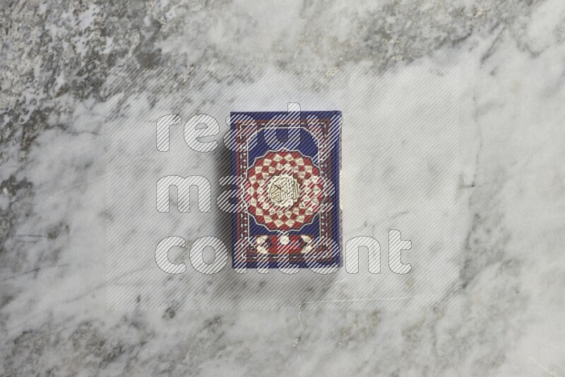 Quran with a prayer beads on grey marble background