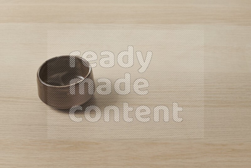 A multicolored pottery bowl on light wooden background