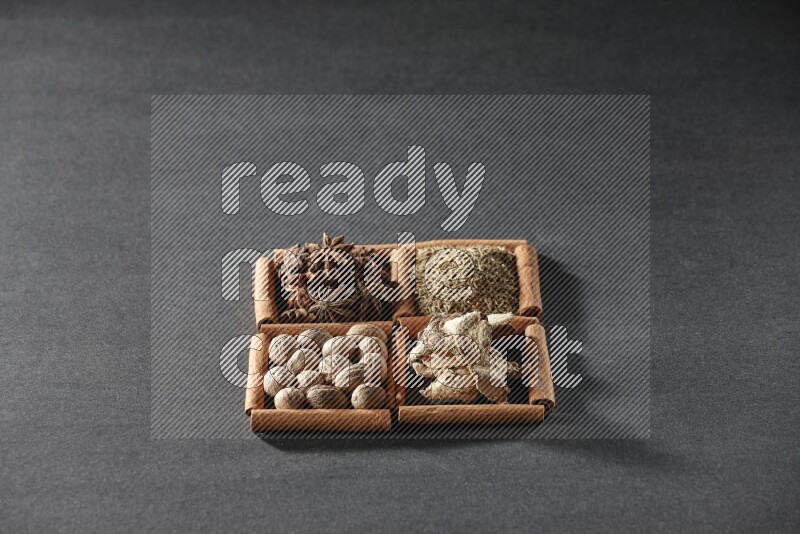4 squares of cinnamon sticks full of star anise, cumin, dried ginger and nutmegs on black flooring